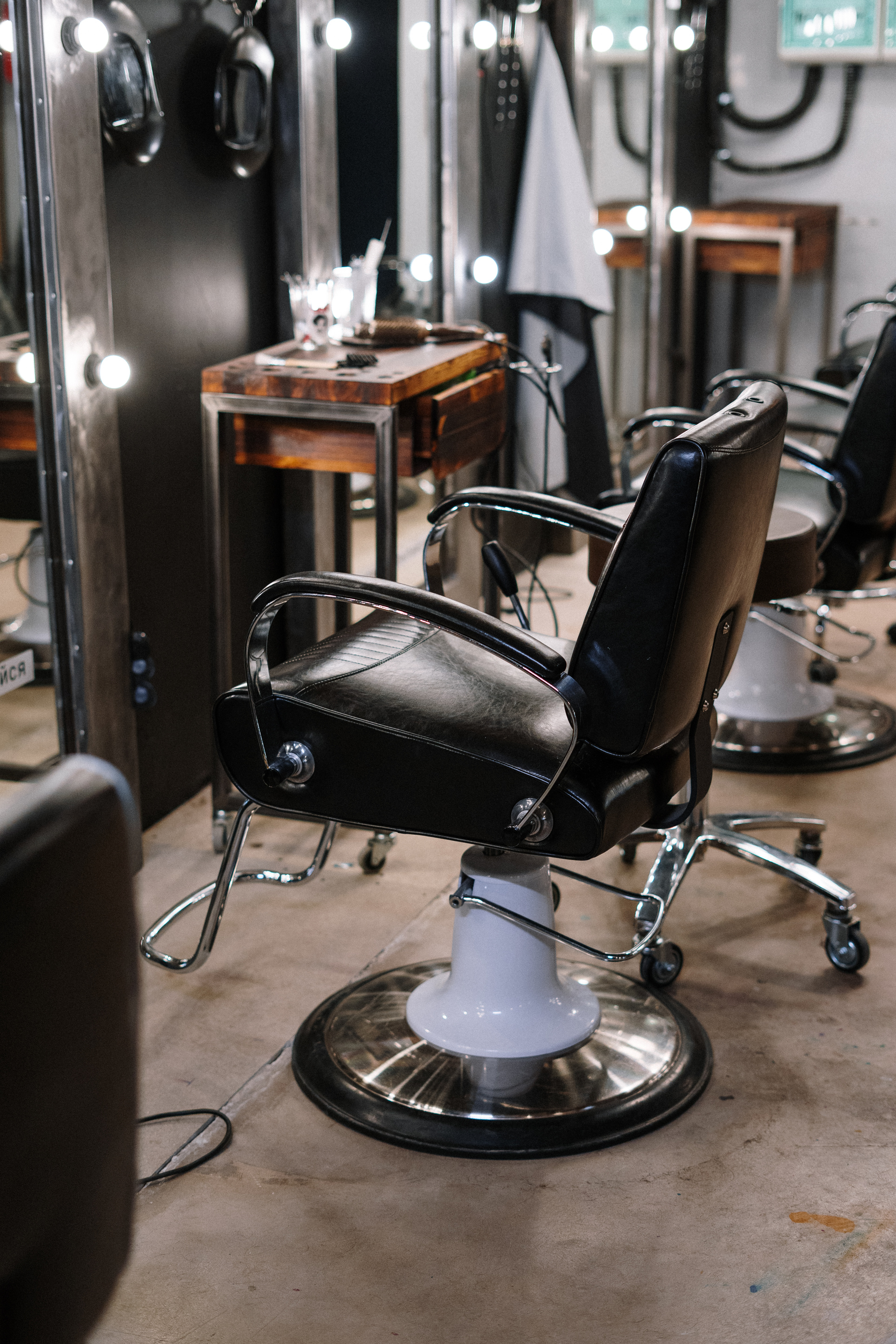 Black Leather Barber Chair in Front of Mirror